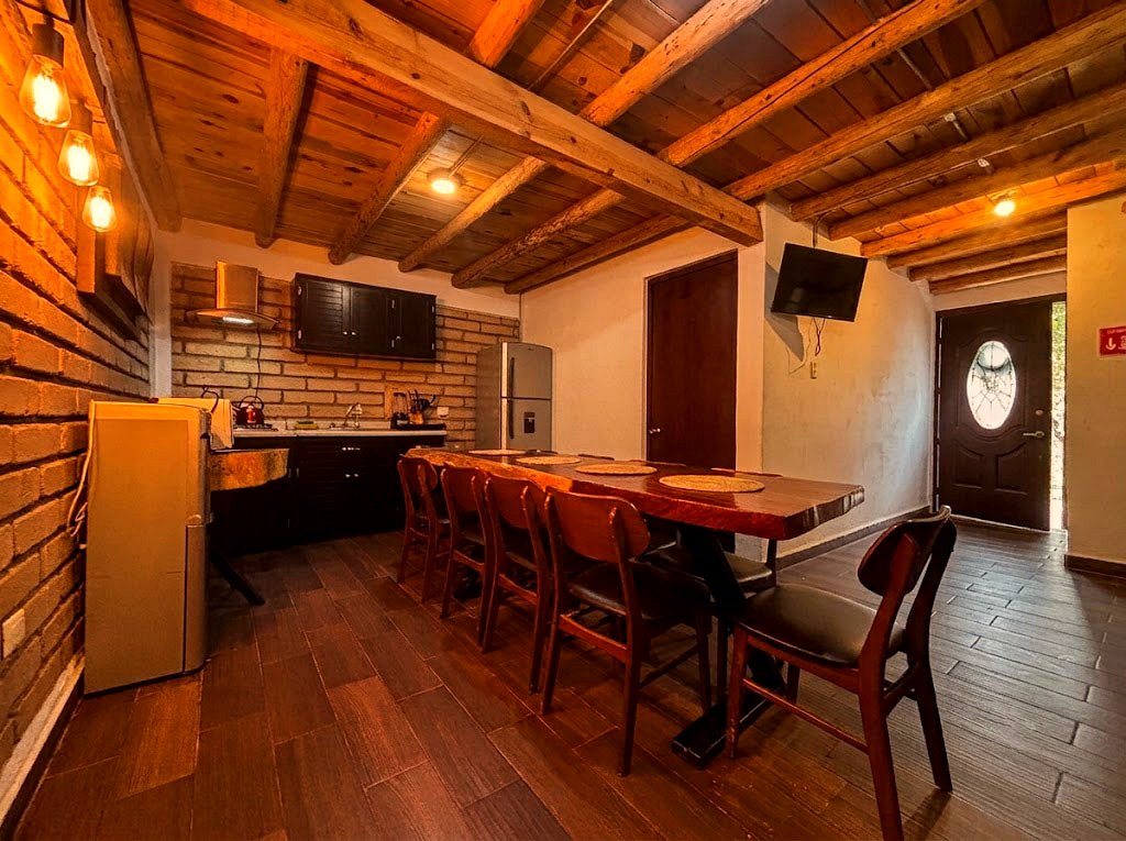 Cocina y comedor de OSA MAYOR con vigas de madera, mesa larga para ocho personas y cocina equipada