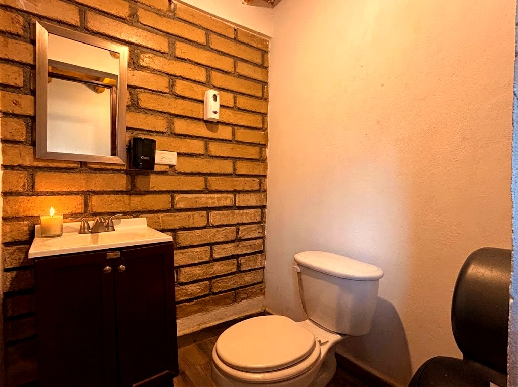 Medio baño de OSA MAYOR con paredes de ladrillo, lavabo y detalles rústicos