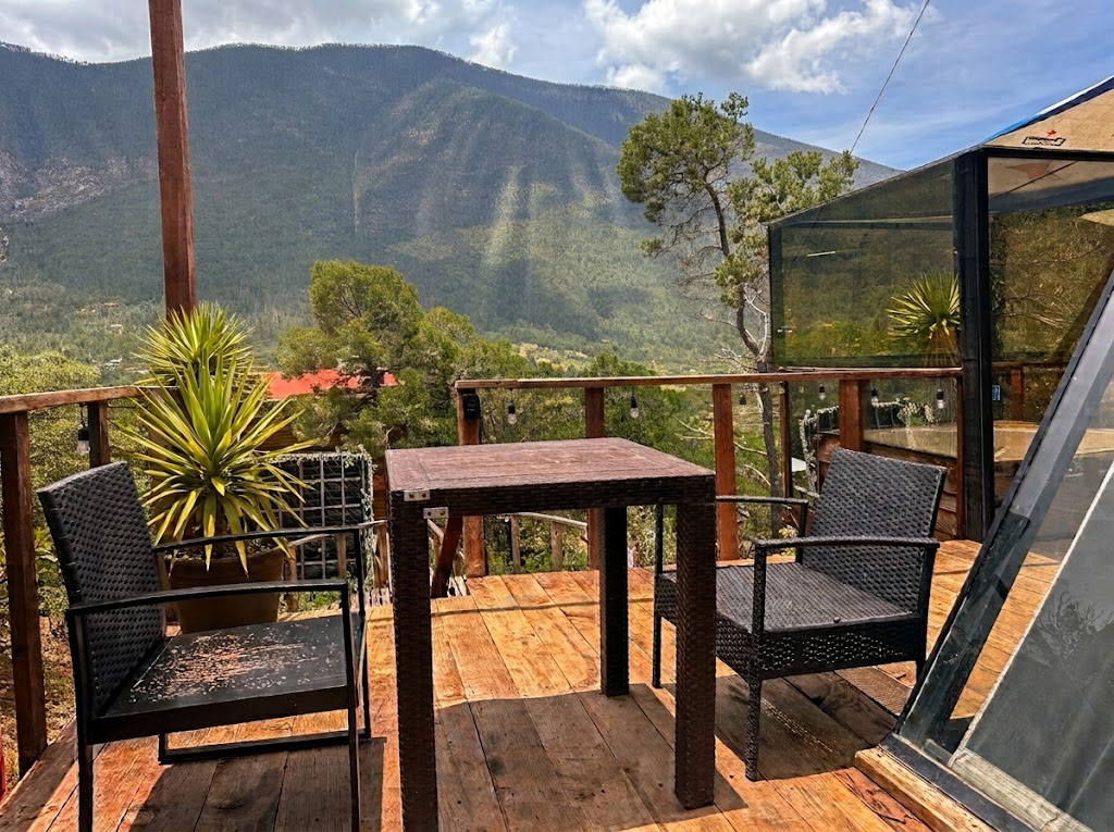 Terraza privada de SIRIUS con mesa, sillones y vista panorámica a las montañas boscosas de la Sierra de Arteaga