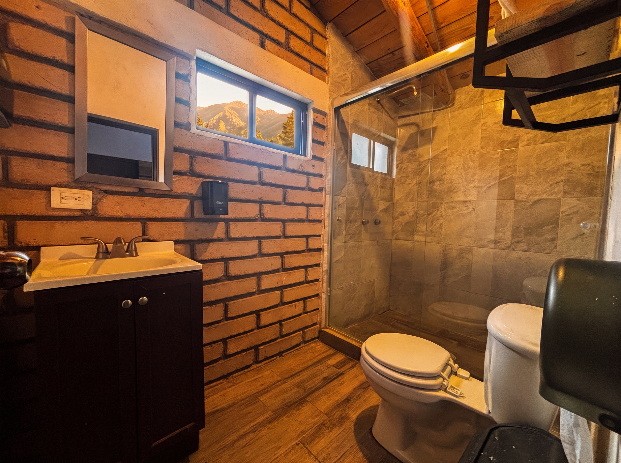 Baño de ANDROMEDA con muros de ladrillo, techo de madera y regadera con cancel de cristal