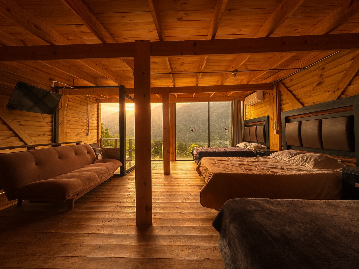 Recámara de ORION al atardecer con luz dorada bañando las camas, sillón y ventanales con vista a la sierra