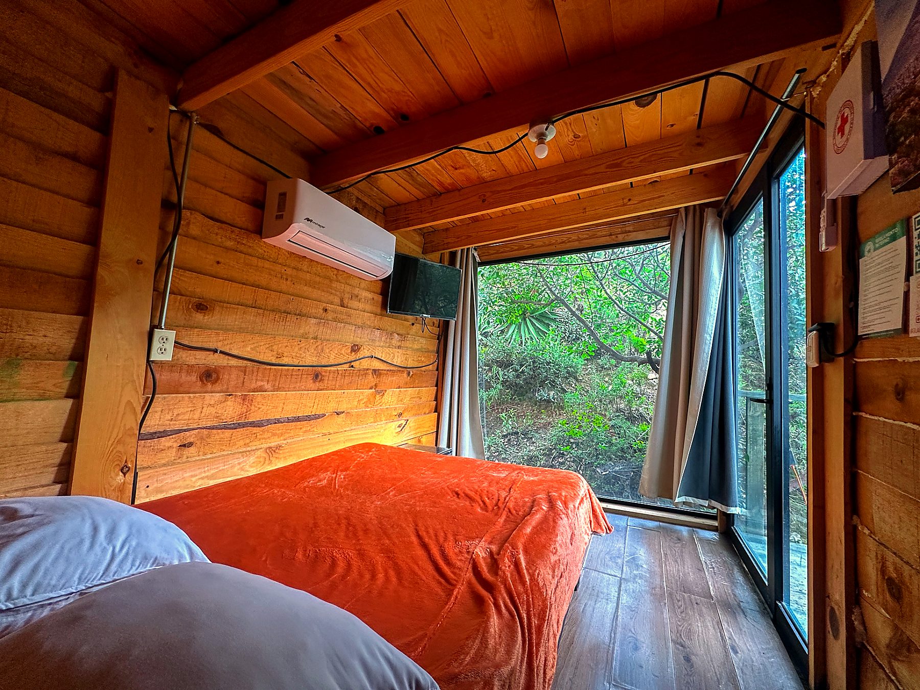 Recámara adicional de AURORA BOREAL con cama, ventanal panorámico al bosque, climatización y Smart TV